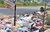 National highway users pass by heaps of garbage